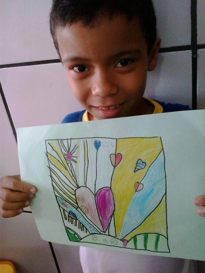 Aluno mostrando um desenho que produziu em aula de artes