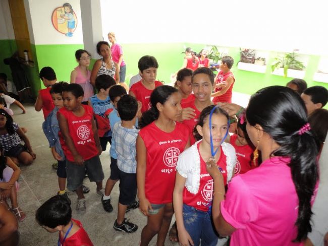 Grupo grande de alunos reunidos no pátio durante a gincana da escola