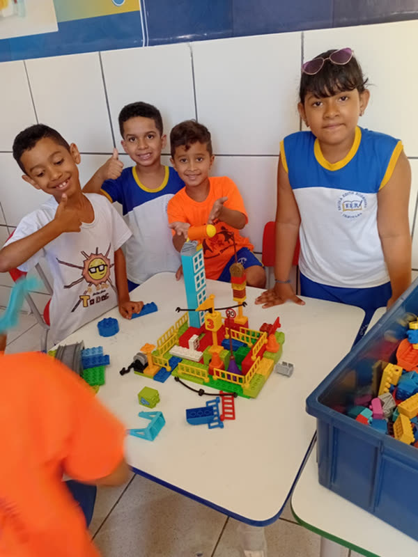 Alunos montando peças de encaixe sobre a mesa em atividade de construção